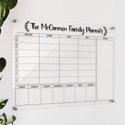 Personalized clear acrylic 'The McCannon Family Planner' with named columns and a weekly date grid