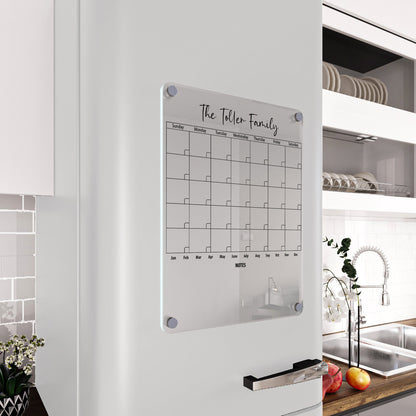 Personalized clear acrylic 'The Toller Family' magnetic fridge calendar with a notes line, on a white refrigerator