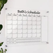 Personalized clear acrylic 'Beth's Schedule' calendar with monthly grid, notes, and dual habit tracker rows