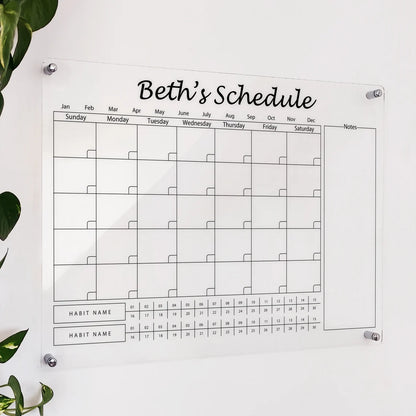 Personalized clear acrylic 'Beth's Schedule' calendar with monthly grid, notes, and dual habit tracker rows