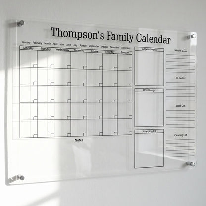 Personalized clear acrylic 'Thompson's Family Calendar' with a monthly grid, appointments, and shopping list sections