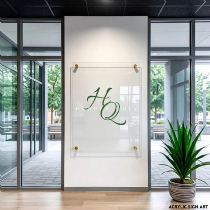 Clear acrylic 'HQ Harper Quin' logo sign in green script lettering with gold standoffs