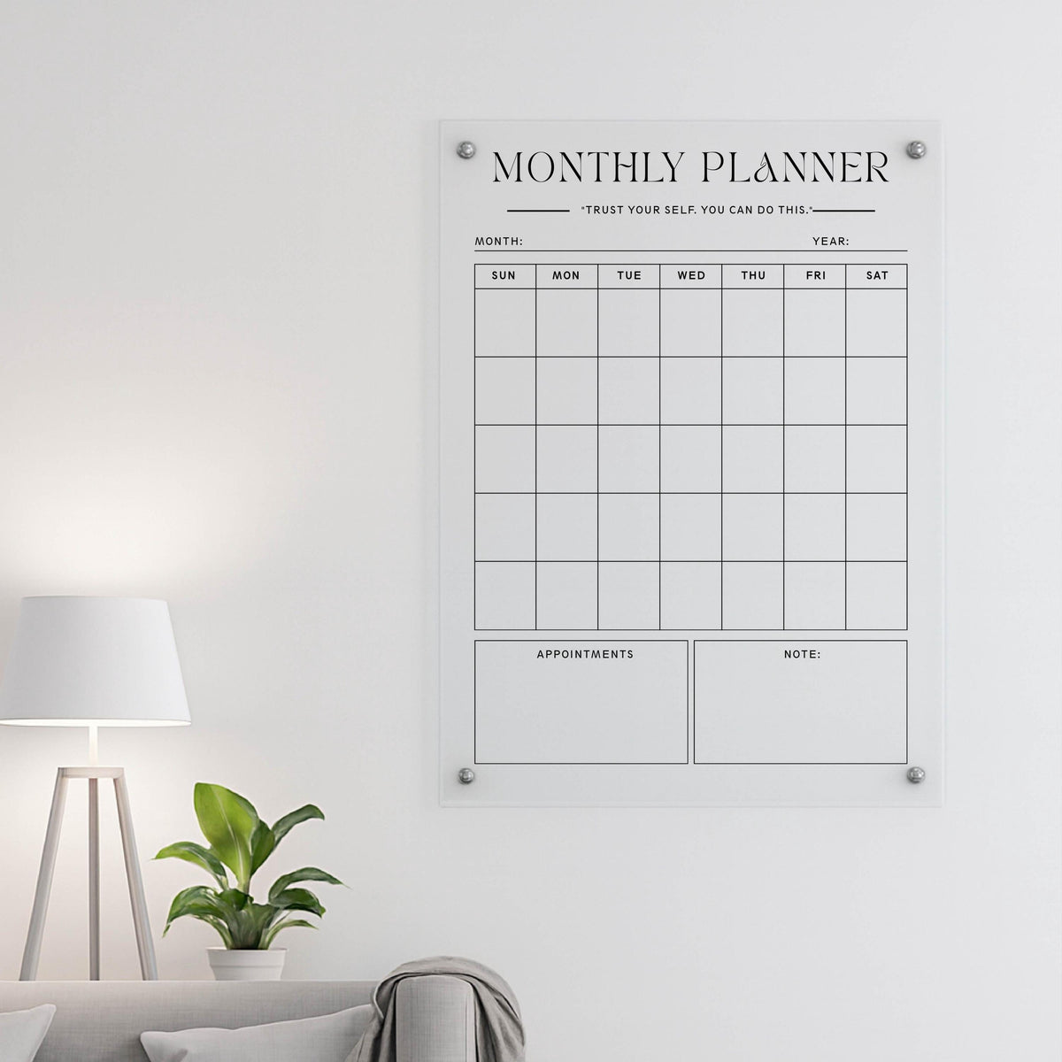 Clear acrylic 'Monthly Planner' board with the quote 'Trust your self. You can do this.' above a lamp and plant